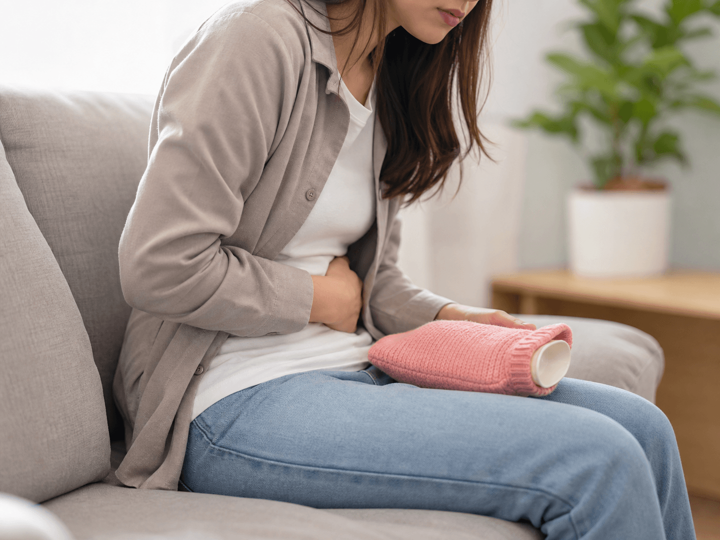 Generated clinical photo showing a person holding the lower abdomen during menstrual cramps